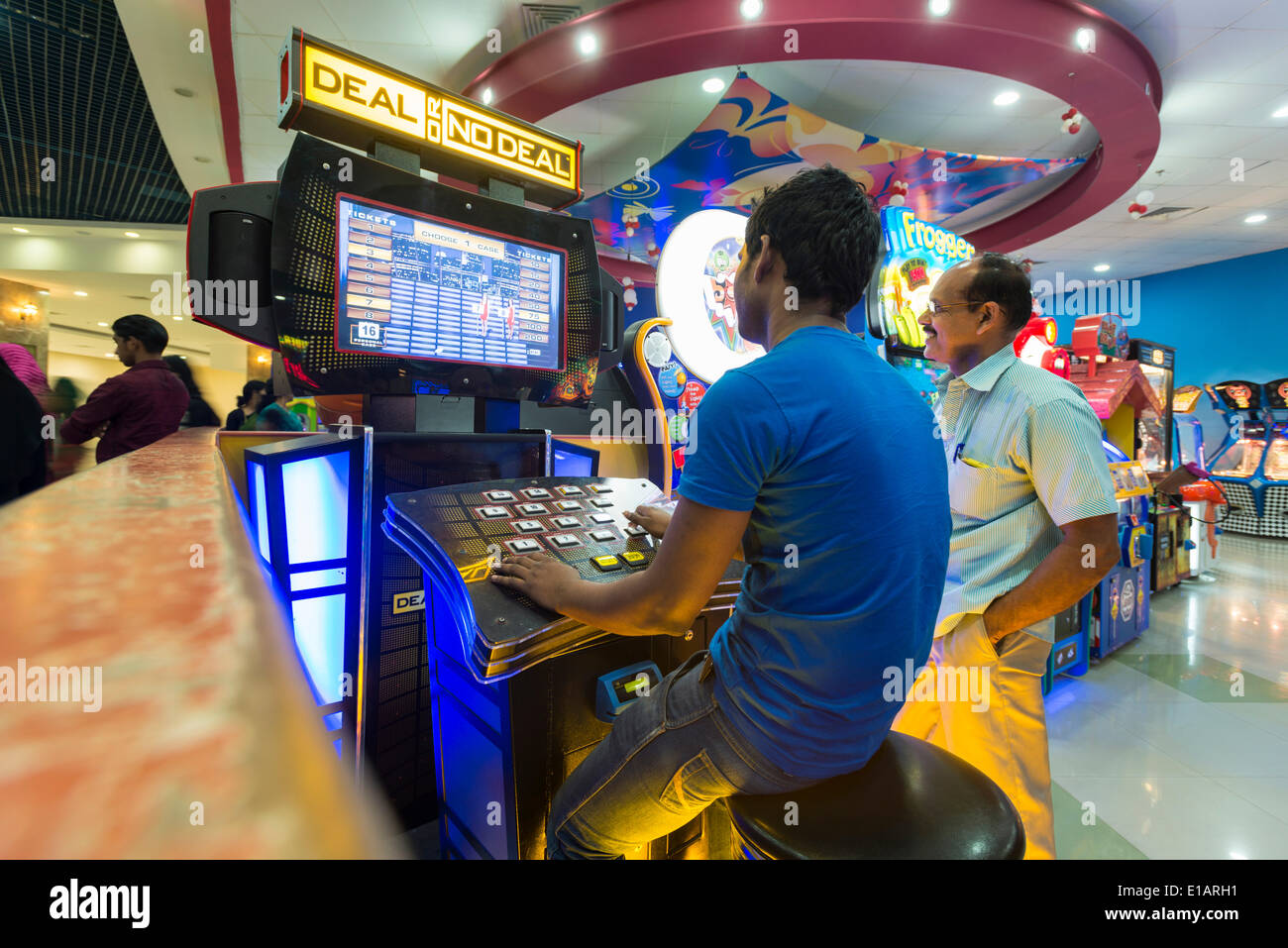 Two men playing at a gaming machine, Lulu Mall, Kochi, Kerala, India Stock Photo