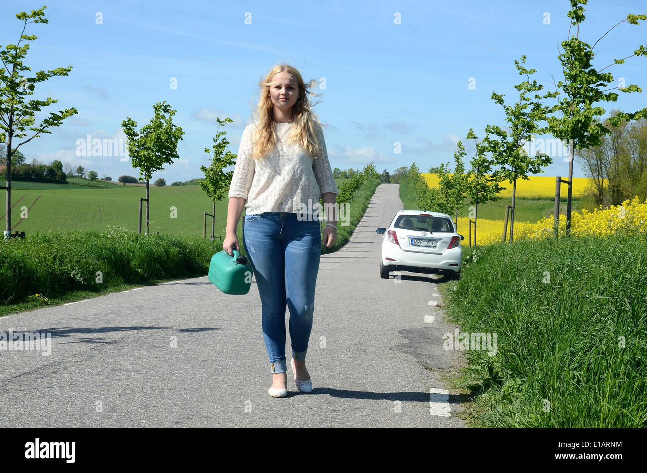 Woman walking away from her car carrying a petrol can, Skåne, Sweden Stock Photo