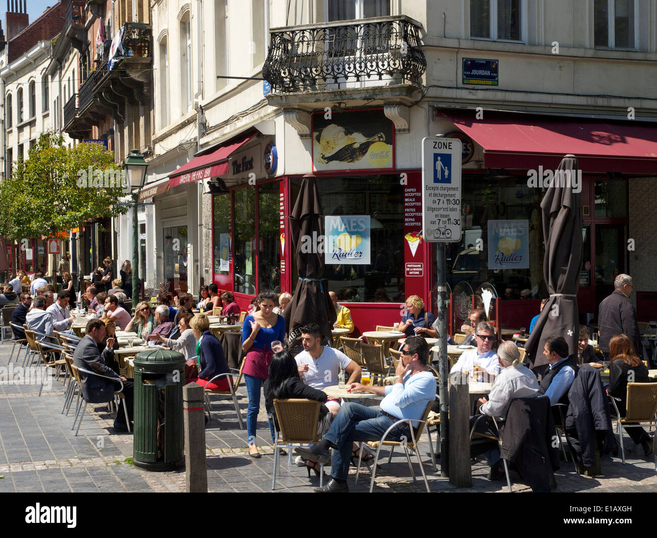 People sitting in the sun at a streetcorner cafe on Jourdan square in the EU district of Brussels, Belgium Stock Photo
