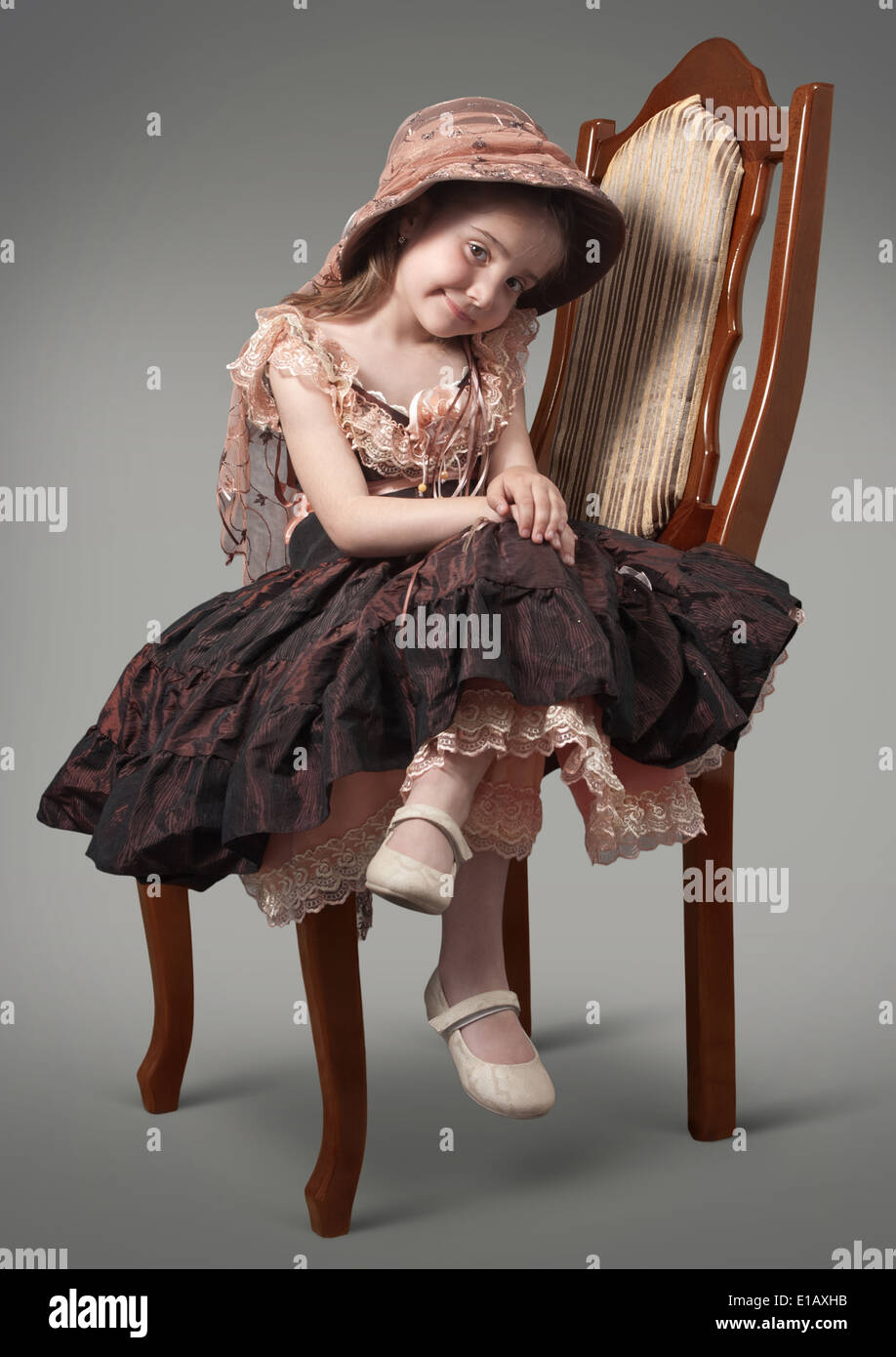 Little girl sitting on a chair a luxurious Stock Photo - Alamy