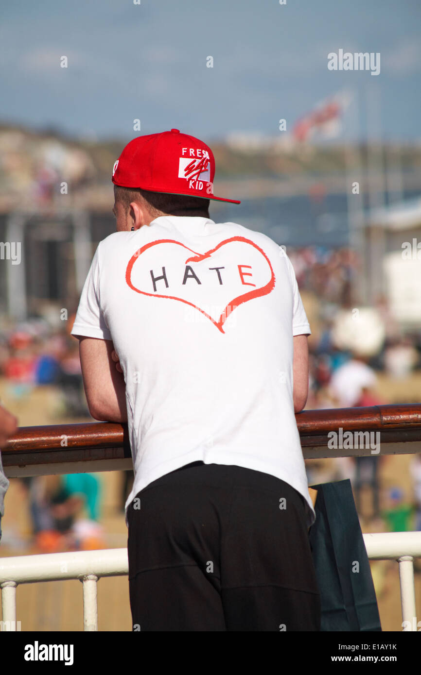 Youth wearing red fresh ego kid baseball cap back to front and hate in  heart on back of t-shirt standing on Bournemouth pier Stock Photo - Alamy