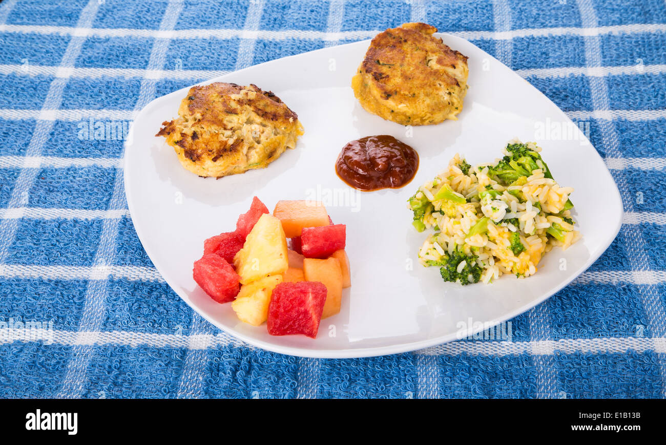 Two hot crab cakes with cocktail sauce, broccoli cheese rice casserole