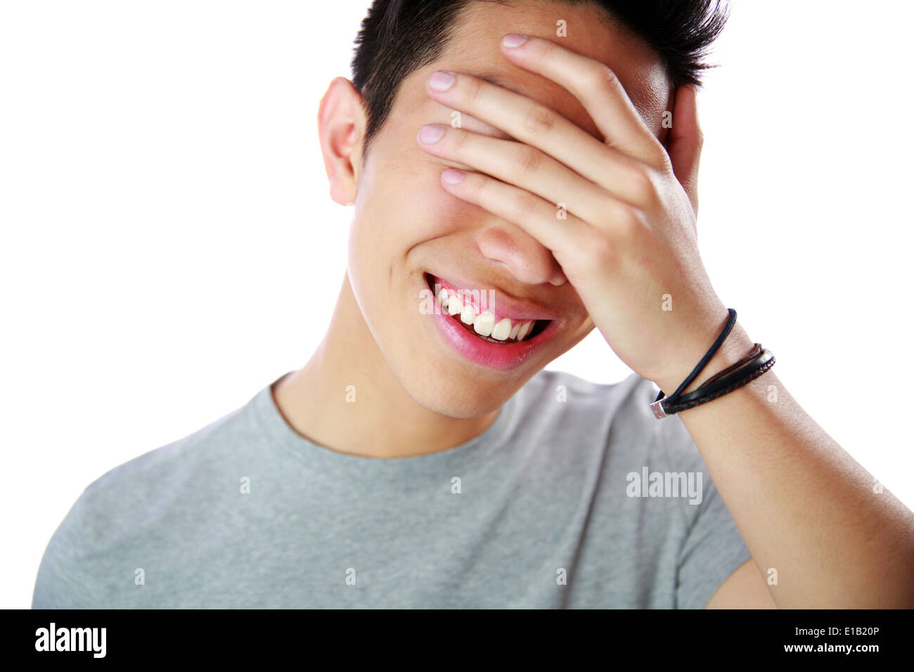 Portrait of a young man covering his eyes with his hand over white ...