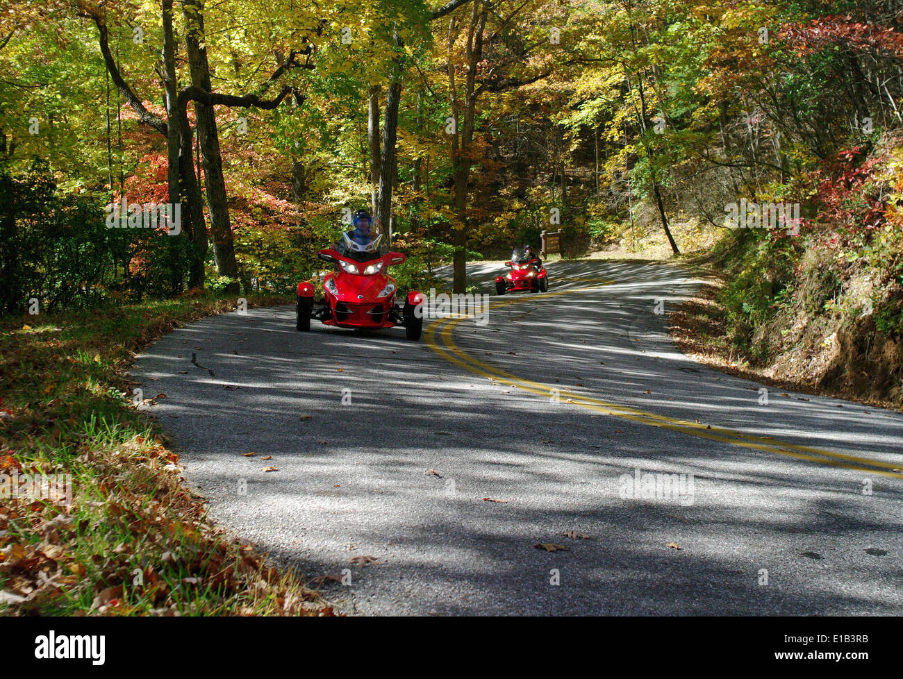 Two Can-Am motorized tricycles ride in the Sosbee Cove area, on Georgia's State Road 180, at the peak of Autumn. Stock Photo