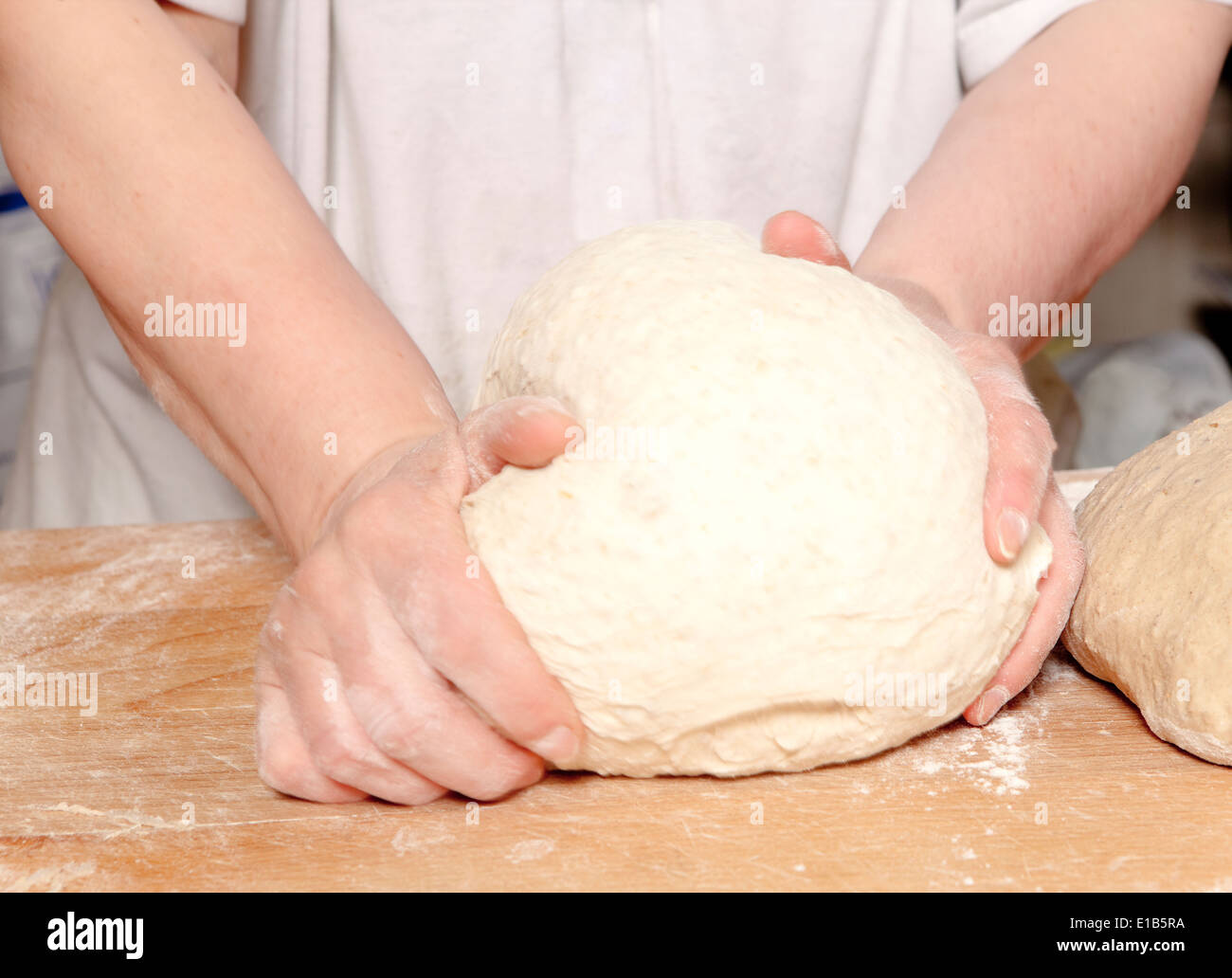 Professional Bakery - Baker Kneading Dough. Stock Photo