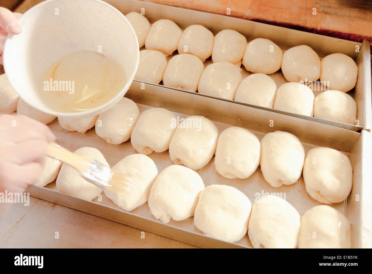 Professional Bakery - Brushing Egg Wash on Pastry Stock Photo