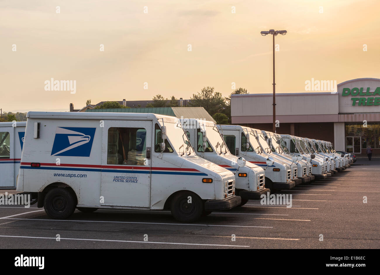 United States Postal Service USPS vans lined up in suburban parking lot at dusk ready for next day deliveries Stock Photo