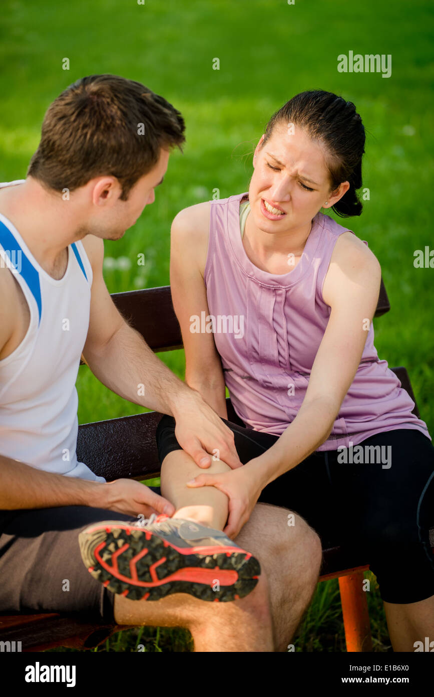 Man helps to woman who injured her leg when jogging Stock Photo Alamy