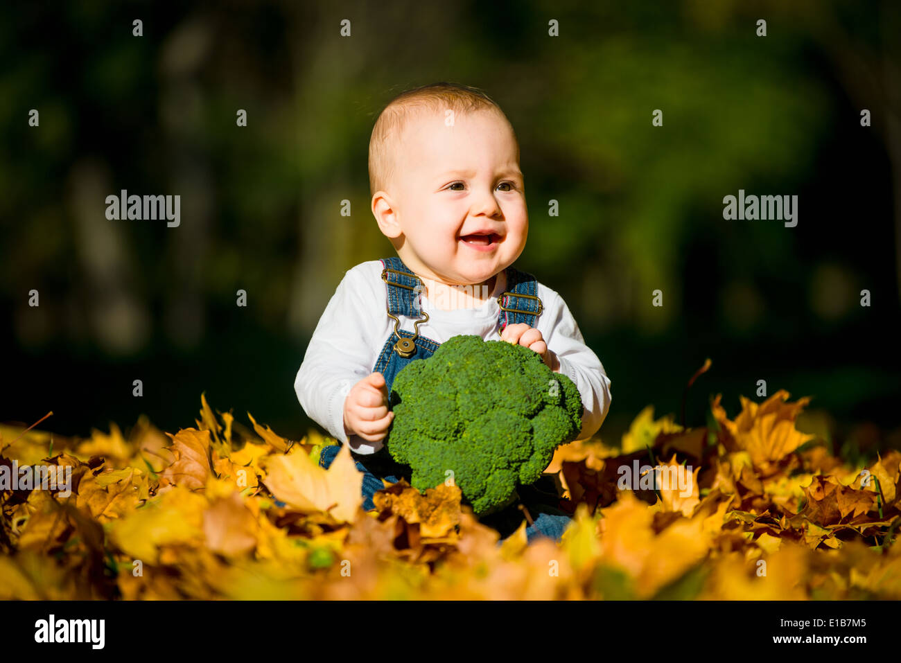 Beautiful baby girl eating food outdoor in nature Stock Photo