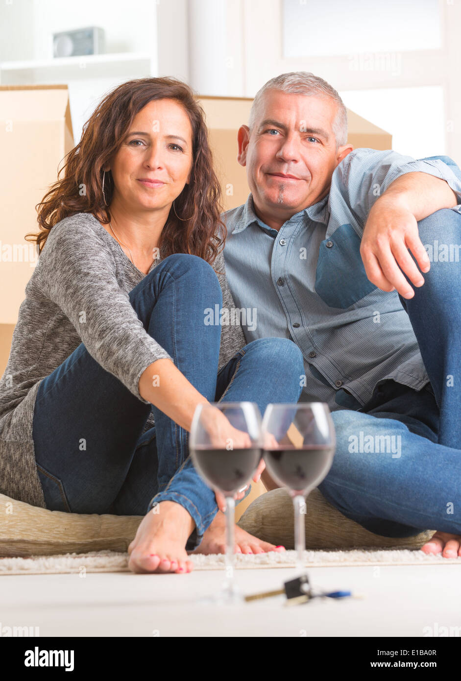 Happy couple celebrating their new home, vine glasses and keys are ...