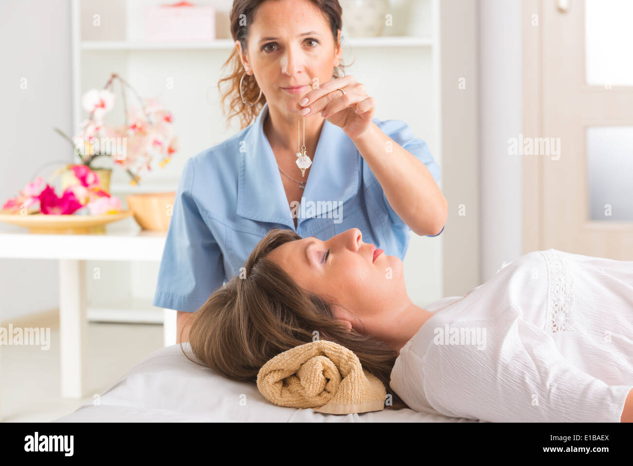 Alternative medicine therapist using pendulum to make a diagnosis Stock