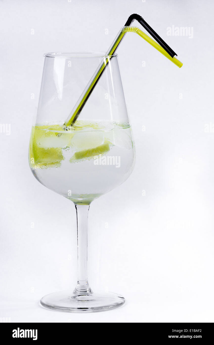 Gin and tonic served in a balloon glass with straws on white Stock