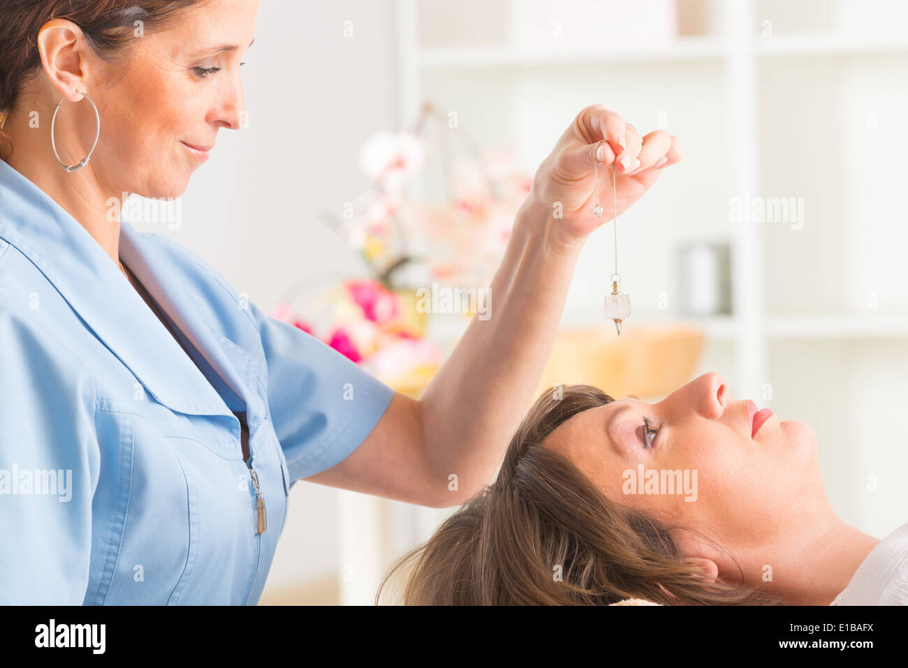 Alternative medicine therapist using pendulum to make a diagnosis Stock