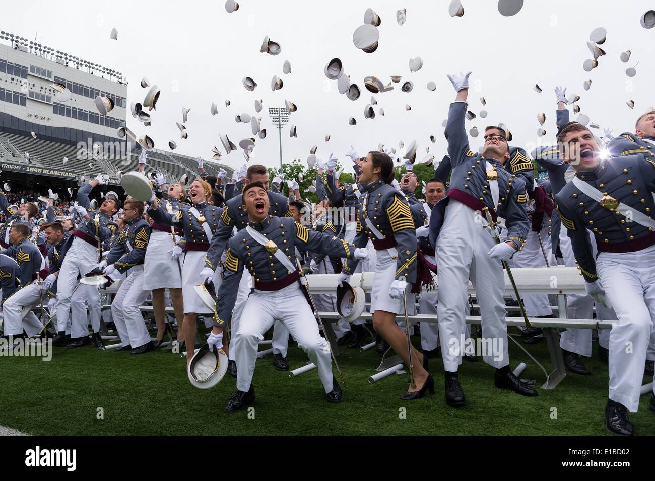 Cadets at the U.S. Military Academy in full parade dress  toss their hats into the air at the completion of the graduation ceremonies May 28, 2014 in West Point, New York. More than 1,000 cadets of Class of 2014 received their diplomas in Michie Stadium and were Commissioned second lieutenants in the U.S. Army. Stock Photo