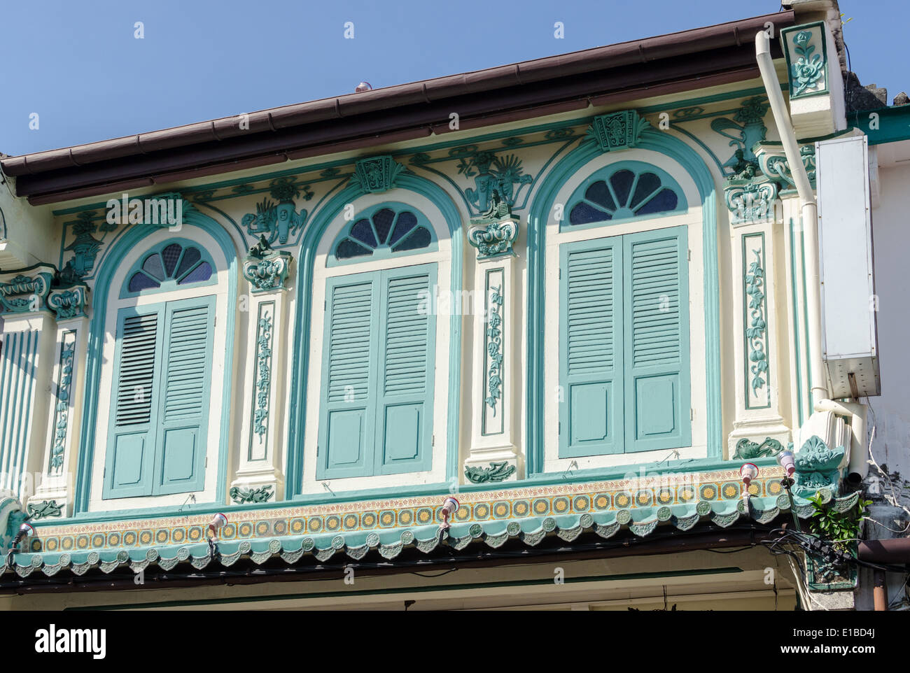 Decorative turquoise plantation window shutters on a building in the Malaysian City of Melaka Stock Photo