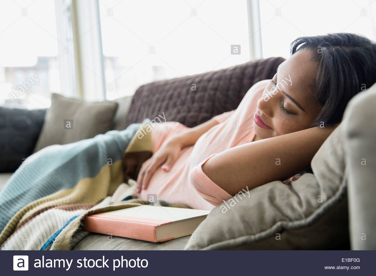 Pregnant woman sleeping on sofa Stock Photo