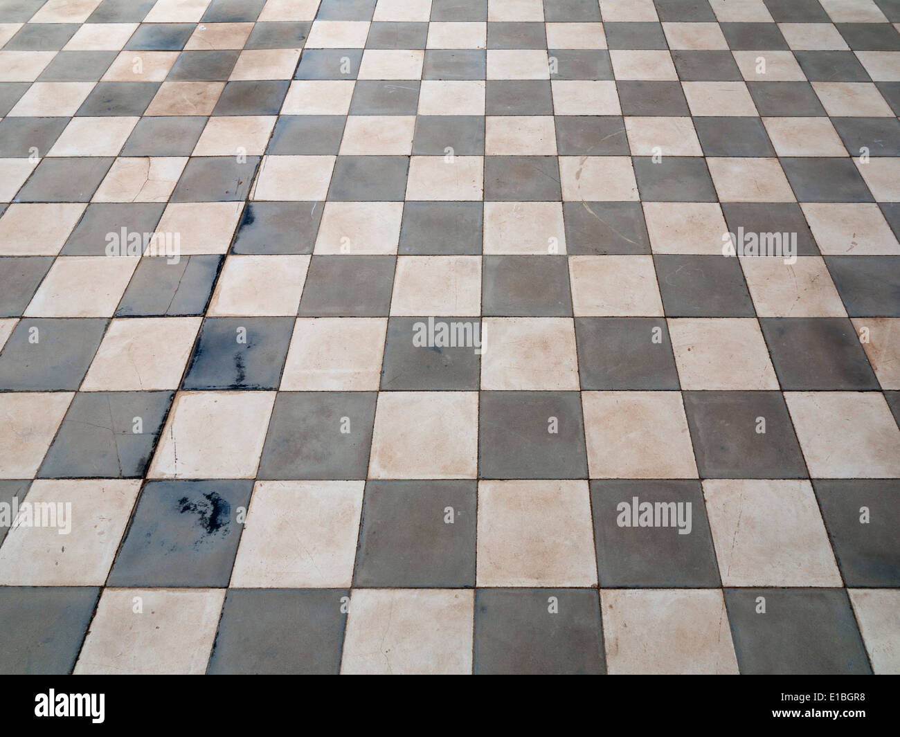 Close up of antique ceramic checkerboard tiled flooring with light shining across Stock Photo