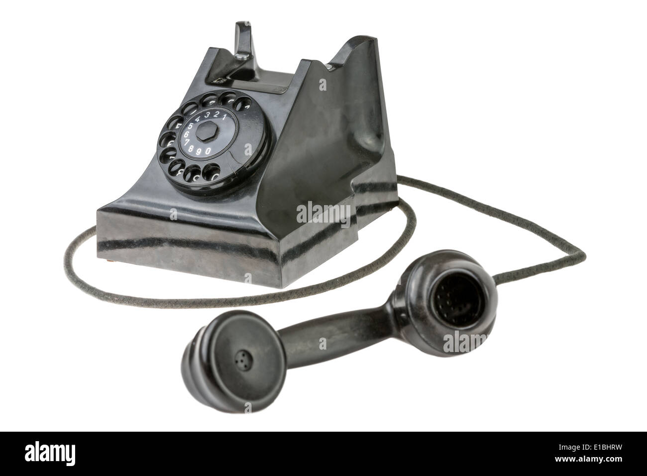 Retro dial-up rotary telephone with the handset lying in the foreground turned towards the camera on a white studio background Stock Photo