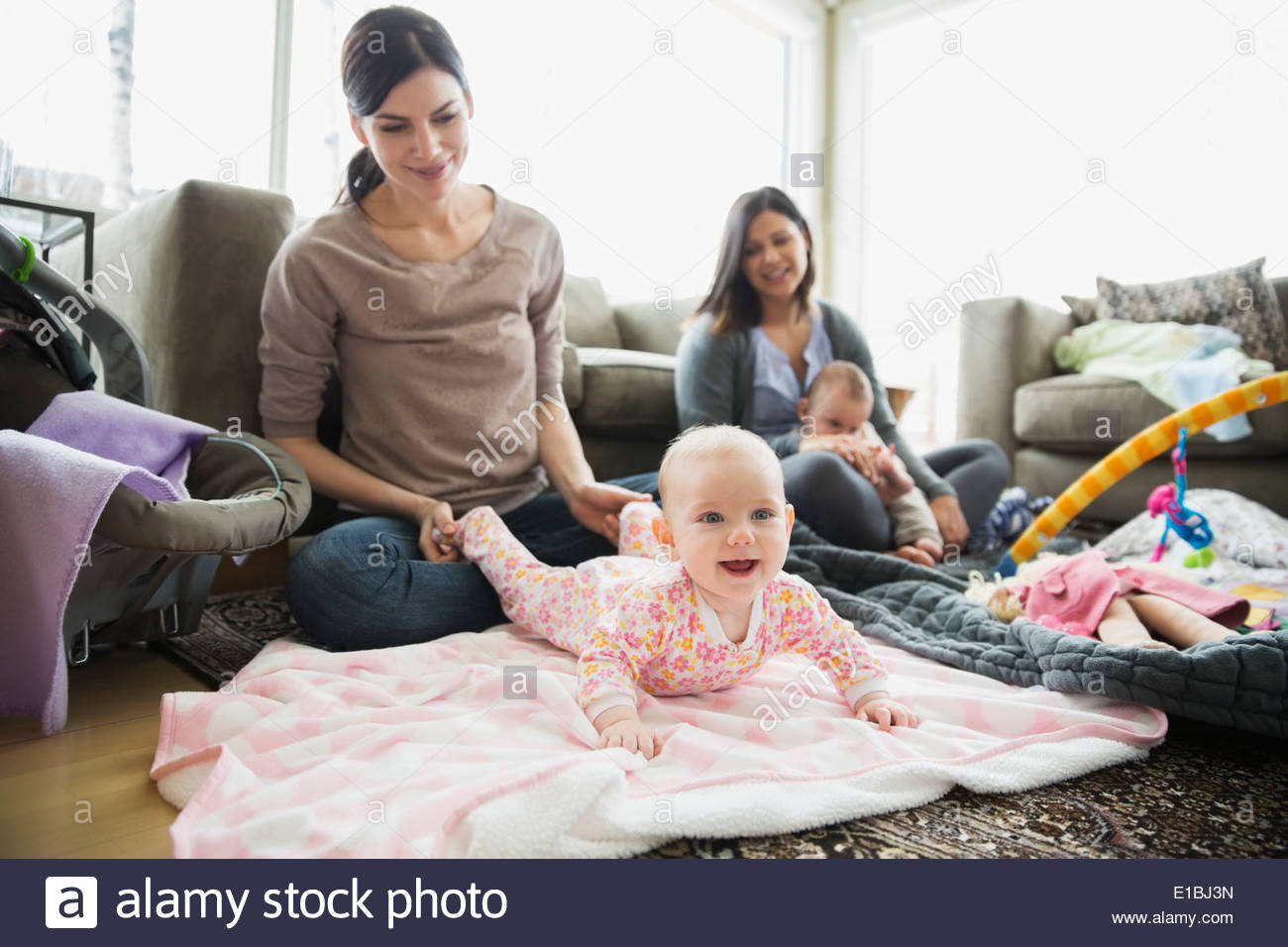 Mothers and babies in living room Stock Photo