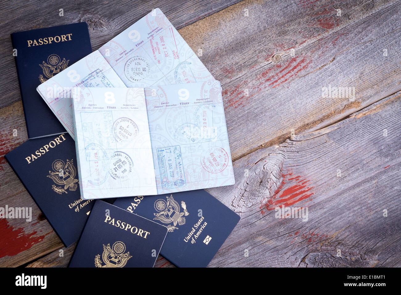 American passports lying on a rustic wooden table open to reveal hand stamps from customs officials on border control applied du Stock Photo