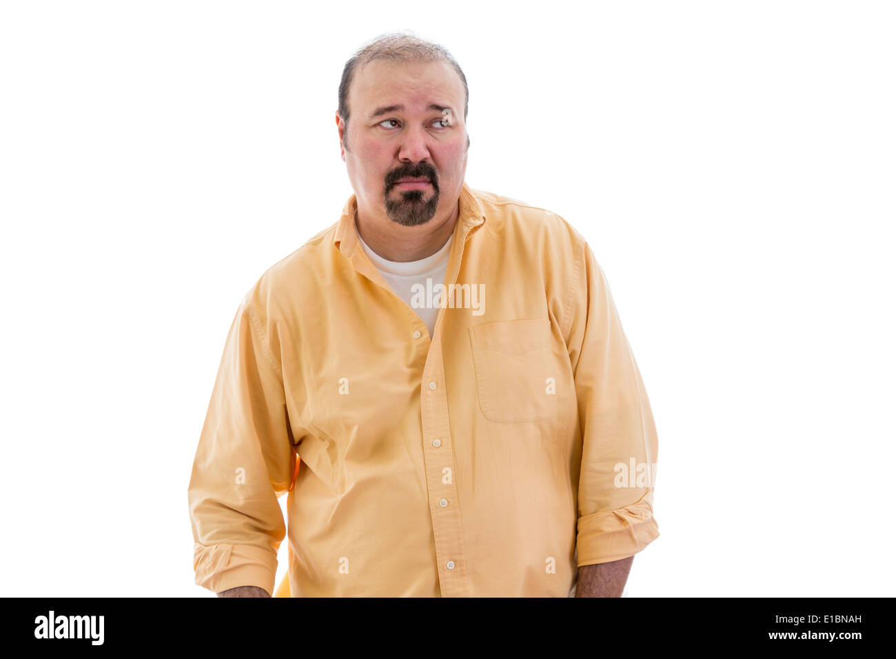 Distrustful sceptical middle-aged man with a goatee standing looking sideways to the right of the frame with a speculative look, Stock Photo