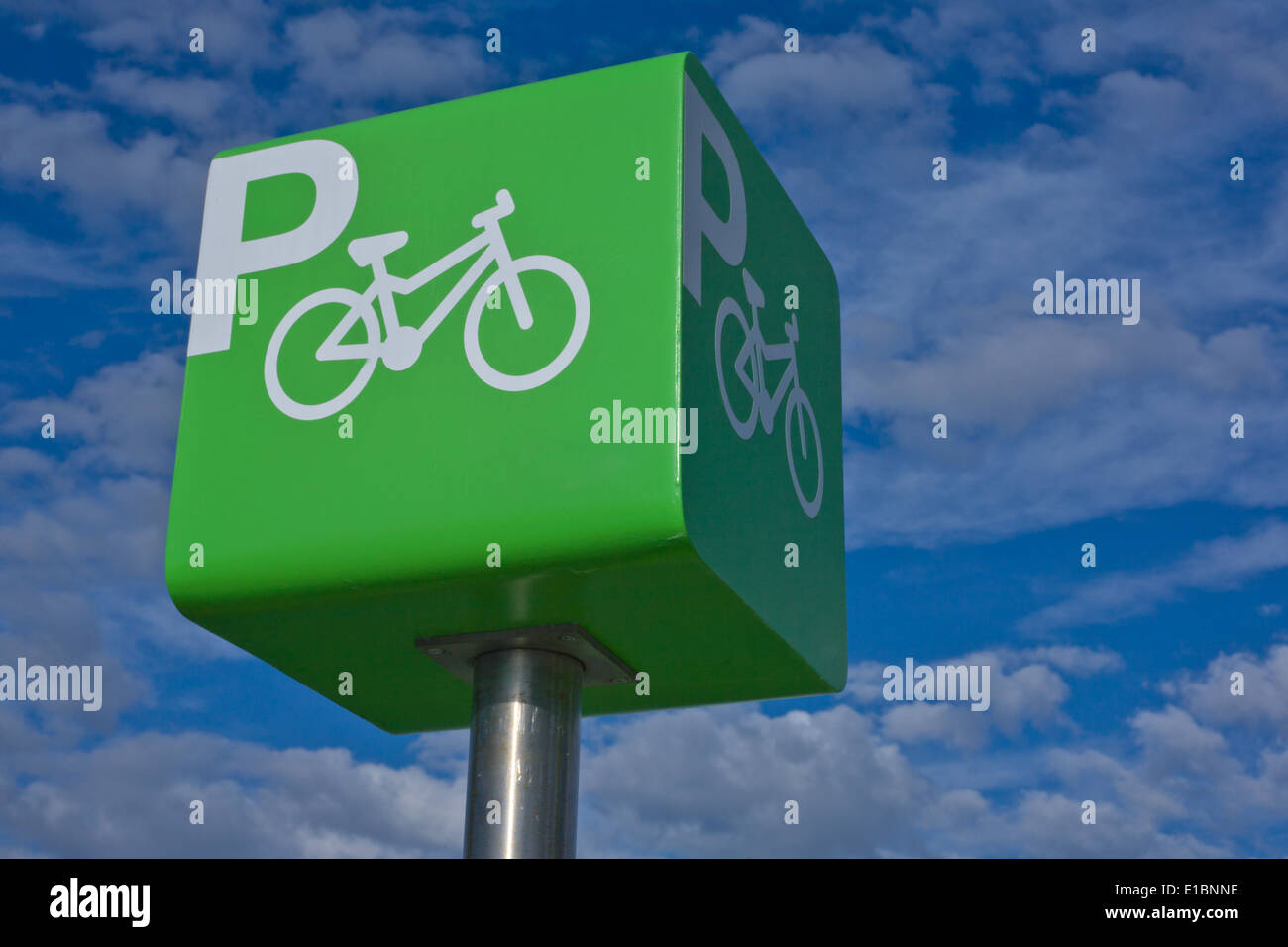 Green parking bicycle pole sign iver blue cloudy sky background Stock Photo