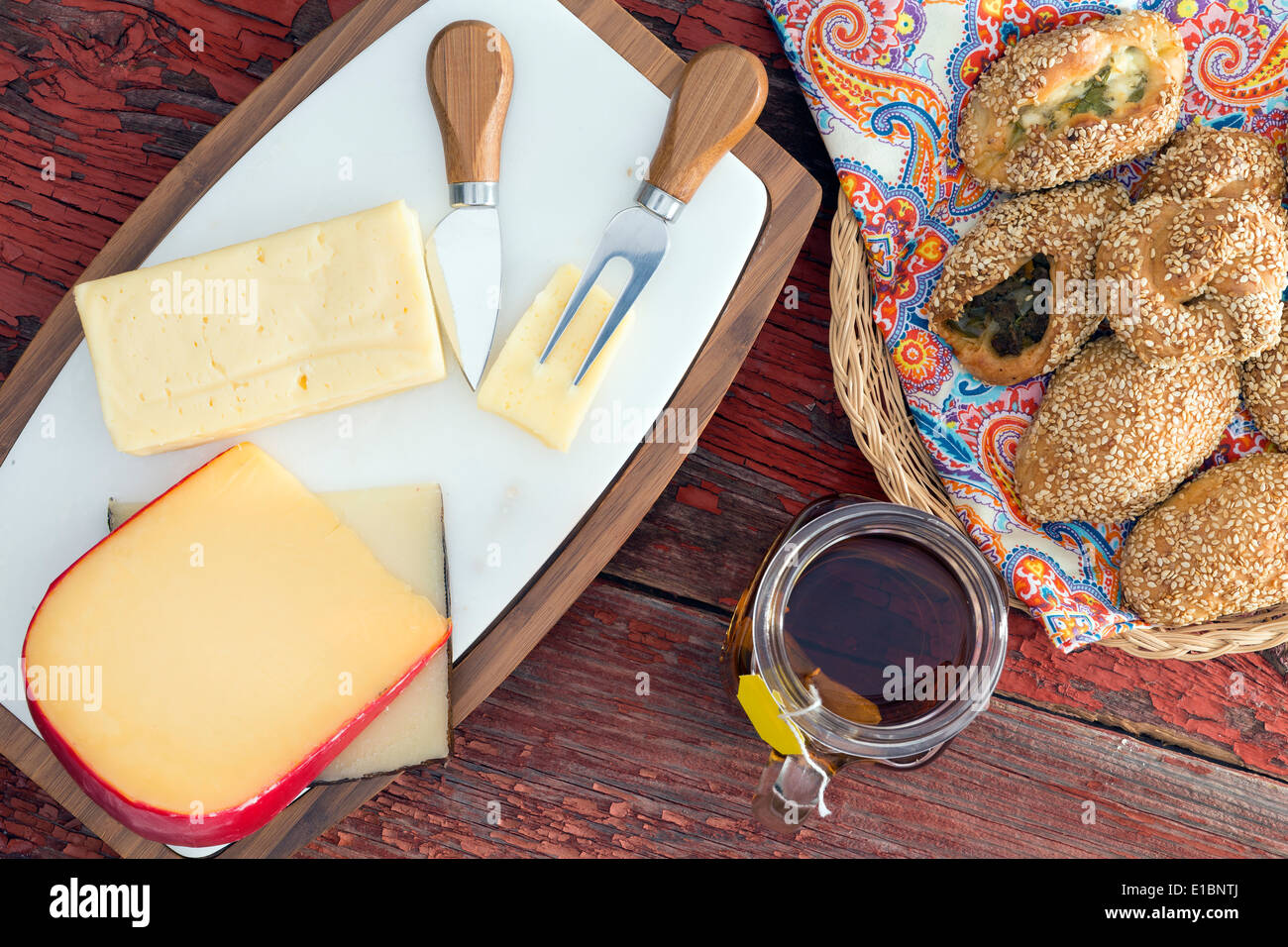 Havarti, manchego and gouda cheese served on a cheeseboard with cutters
