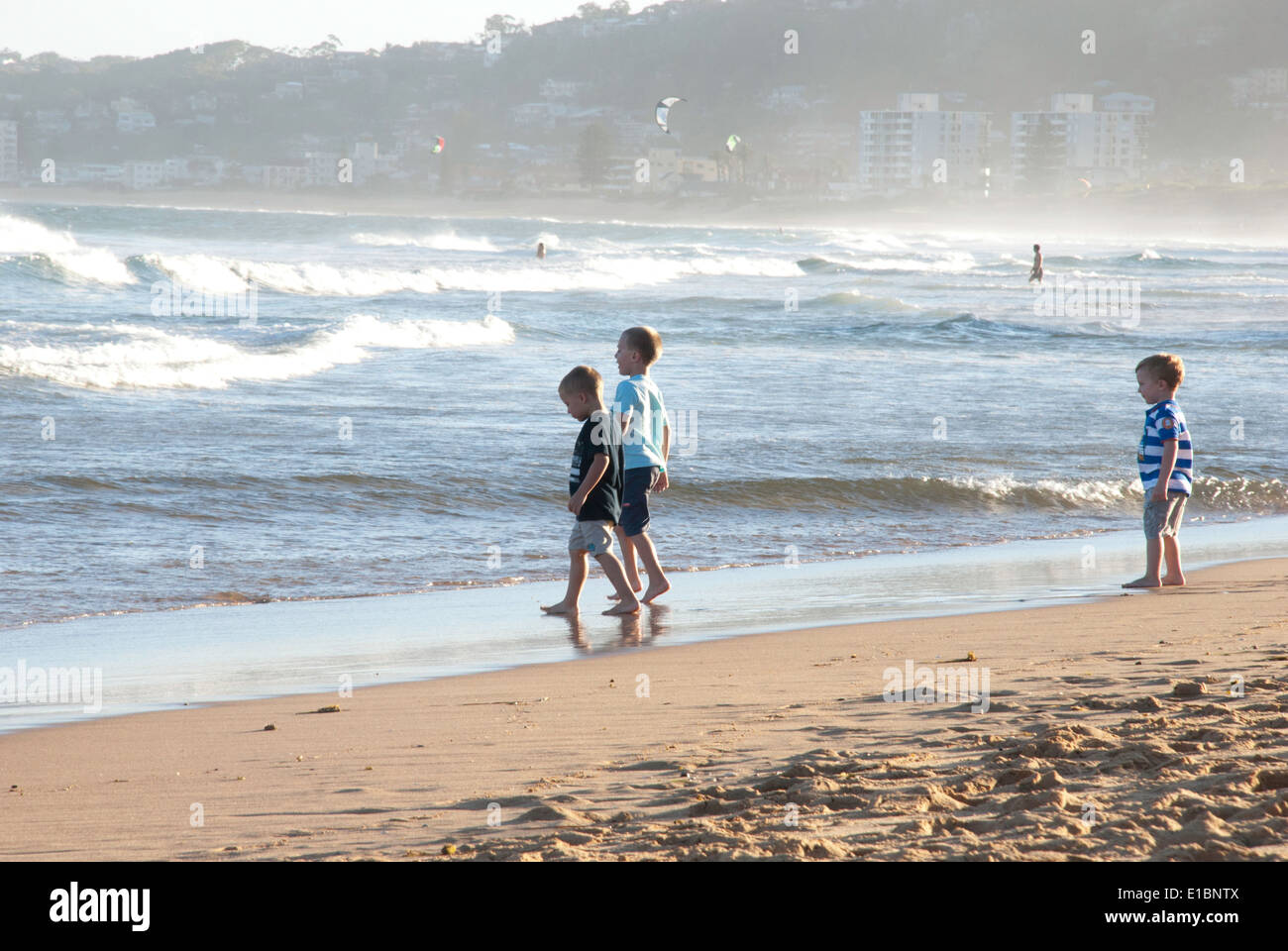Three young boys playing at the shoreline on North Narrabeen beach. Stock Photo