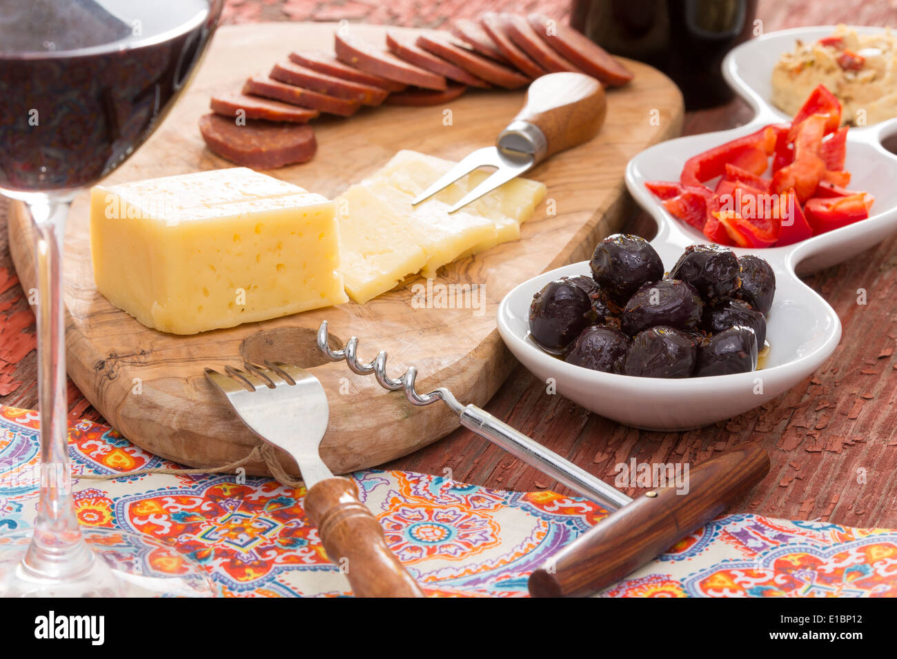 Havarti cheese and savory snacks including black olives, diced red bell