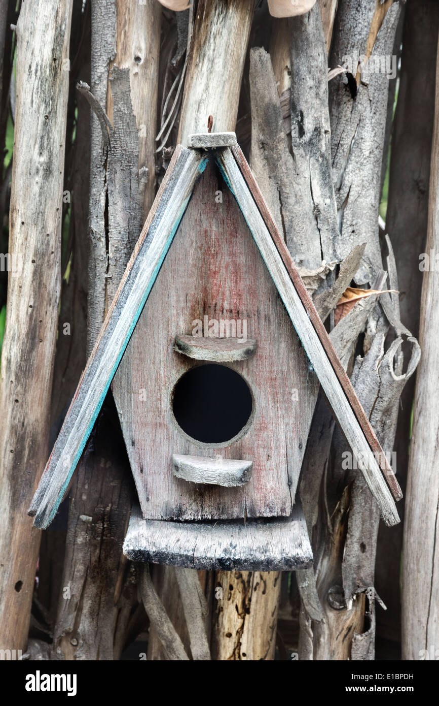 Bird house nesting hanging from wood bit log Stock Photo