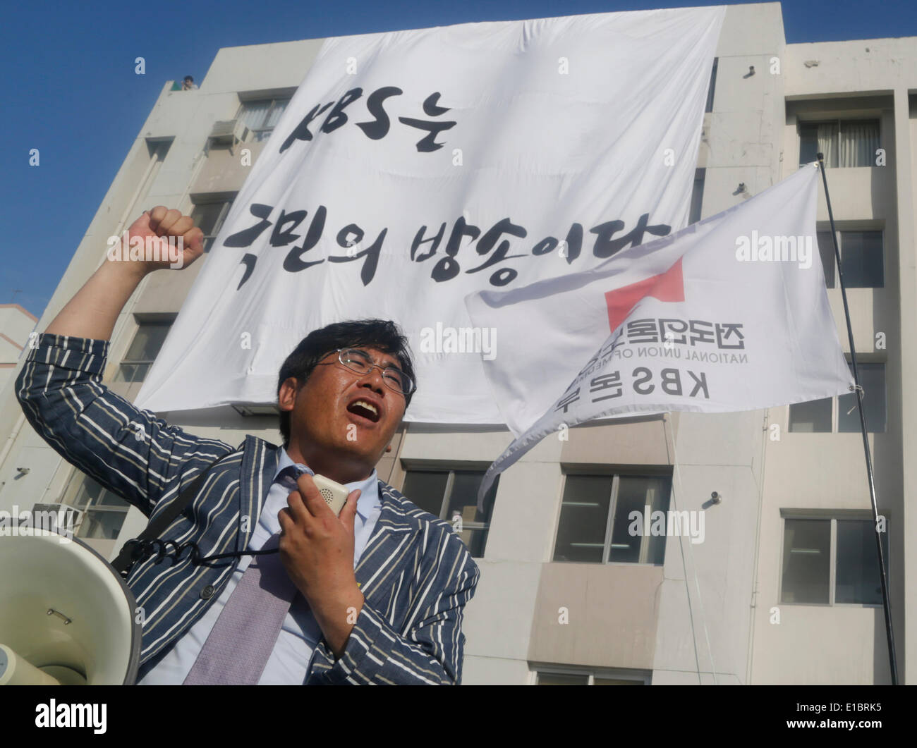 Seoul, South Korea. 29th May, 2014. A journalist of state-run KBS chants slogans during a strike rally near the national assembly in Seoul, South Korea. Journalists and workers of two labor unions of KBS began general strike on Thursday to demand president of the broadcaster Gil Hwan-young resign for what the labor unions insist, interfering in news reports in favor of South Korean government, while the company said the strike was illegal, according to local media. The placard reads,'KBS is broadcast of the people'. Credit:  Lee Jae-Won/AFLO/Alamy Live News Stock Photo