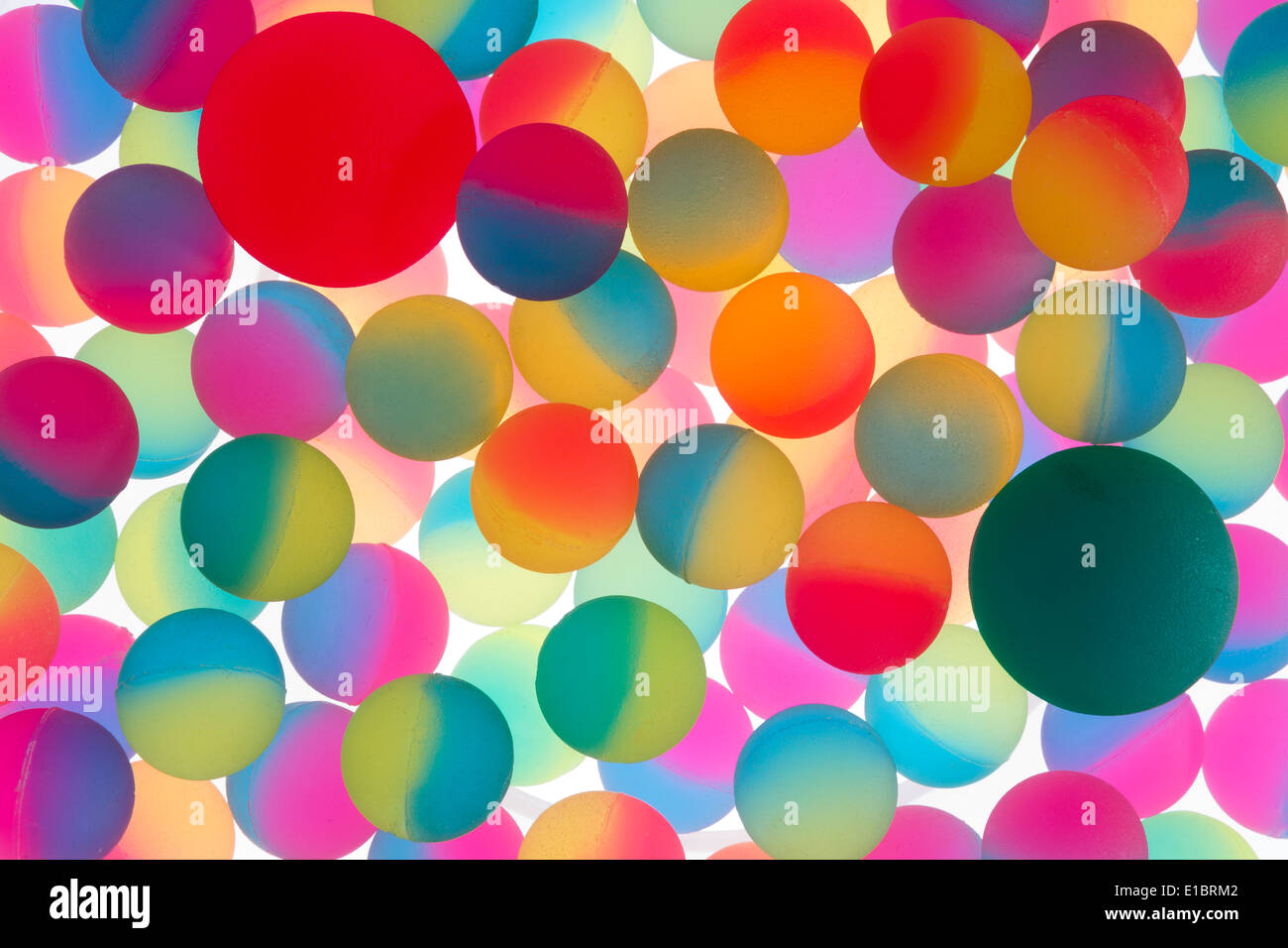 Colorful abstract background of illuminated bicolour plastic balls in the colors of the rainbow in a double layer and random arr Stock Photo