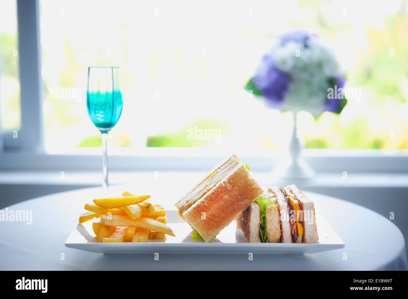 fresh and delicious classic club sandwich with french fries on white disc Stock Photo