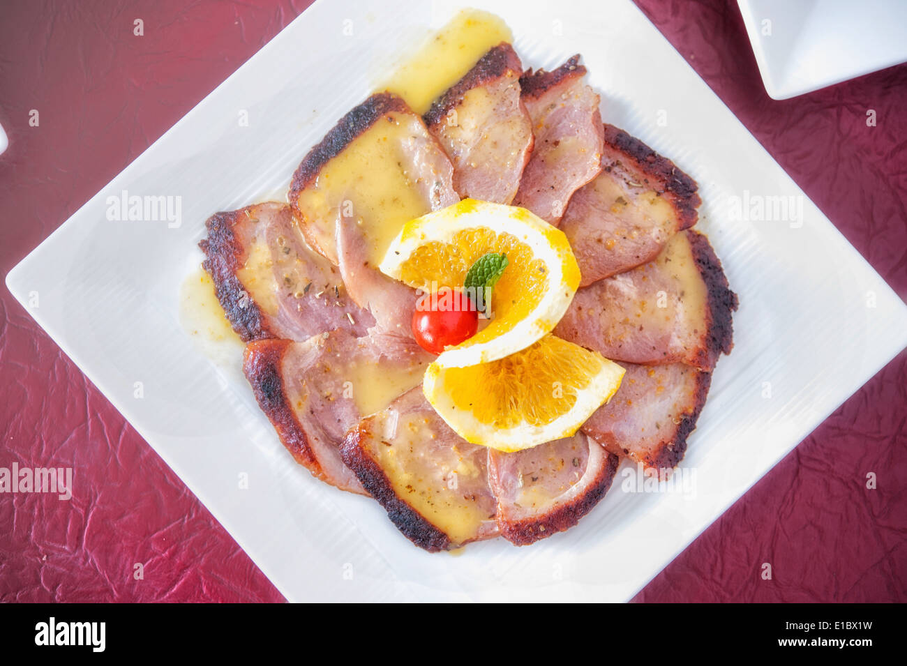 slice grilled steak meat with lemon sauce on white dish Stock Photo