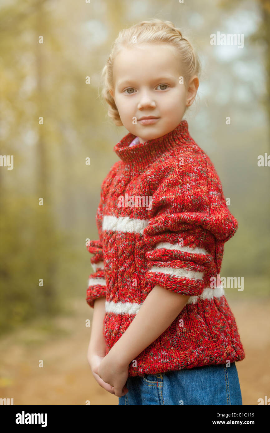 Image of pretty little girl posing in red sweater Stock Photo Alamy