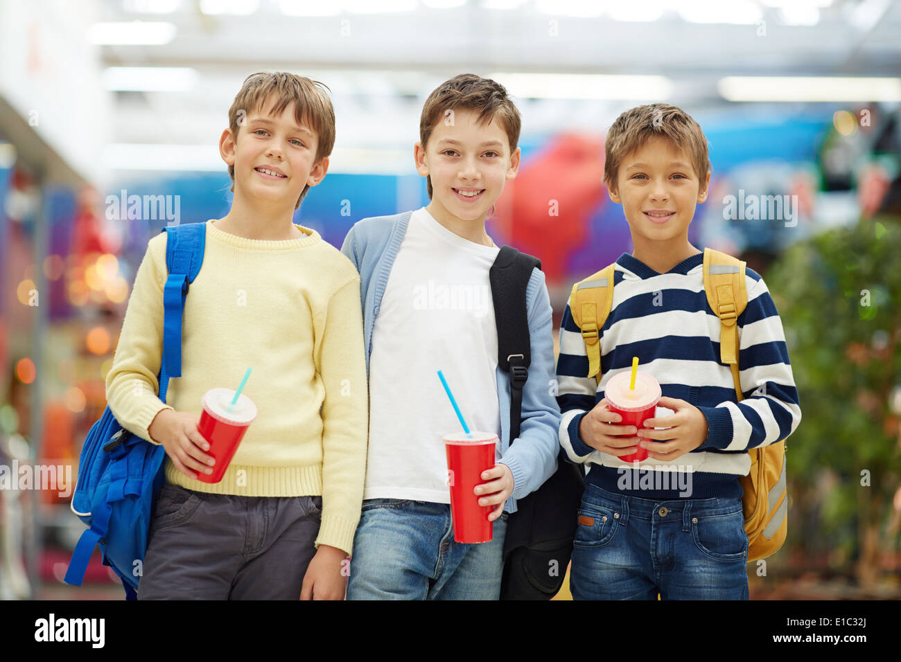 Portrait of three smiling schoolboys with soda Stock Photo