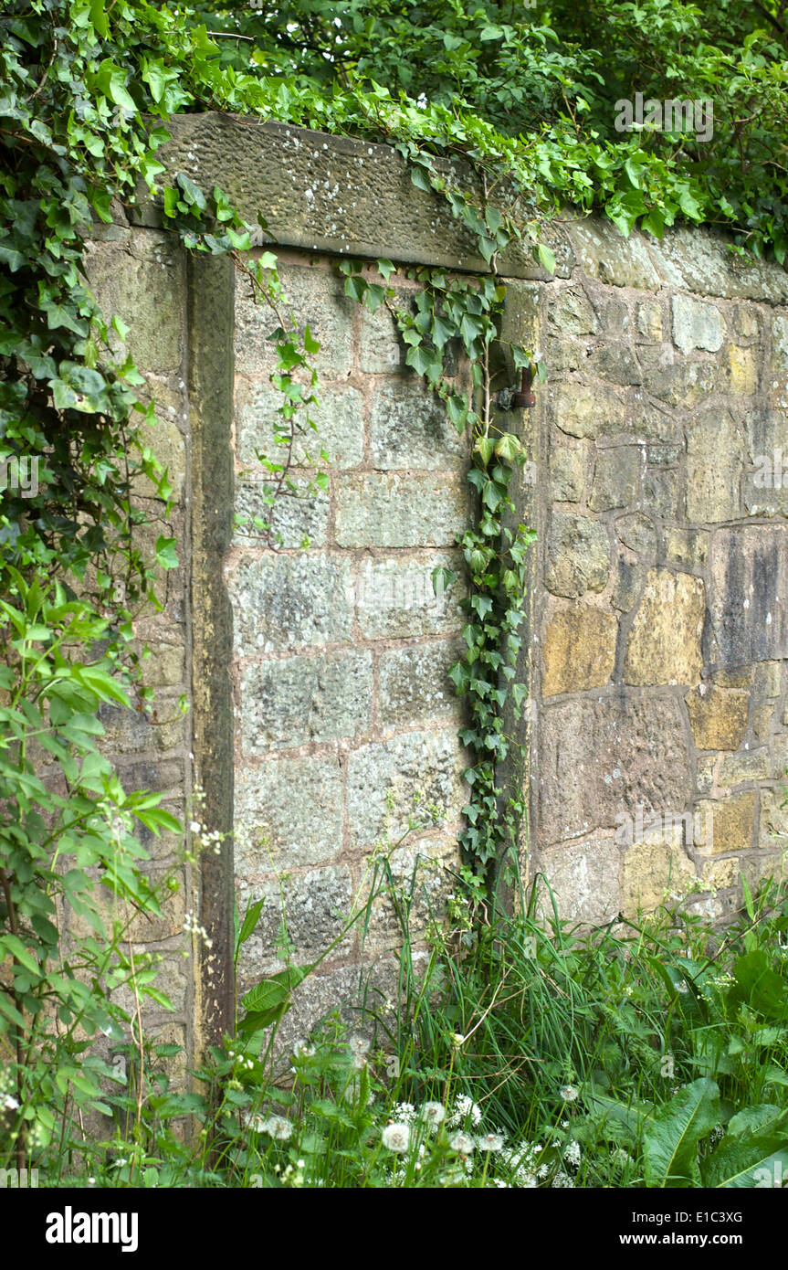 Breeze block filling gap in old stone wall Stock Photo