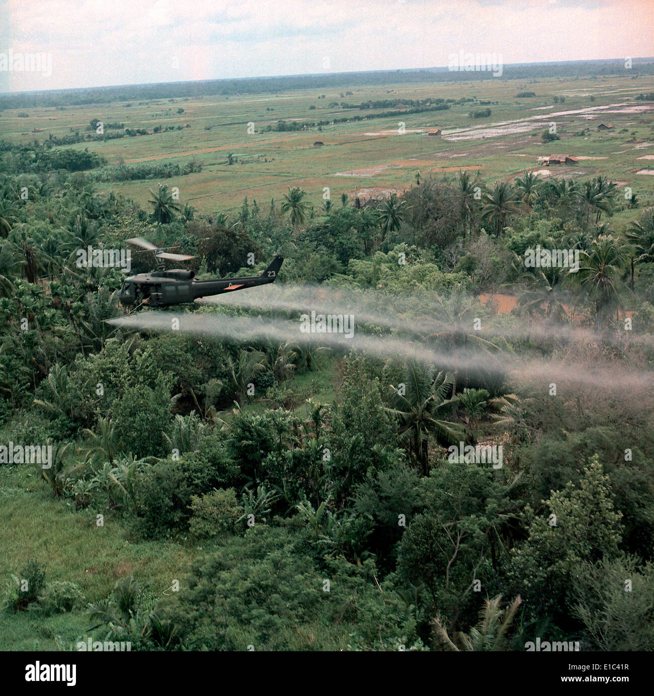Vietnam War, Defoliation Mission, a UH-1D helicopter from the 336th Aviation Company sprays a agent orange on a dense jungle Stock Photo