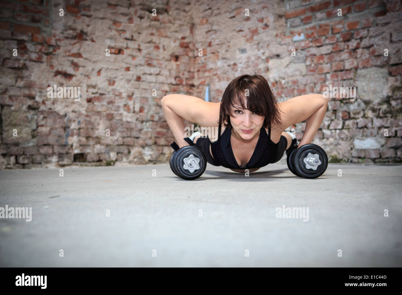 young woman with barbells at fitness exercise in a gym Stock Photo