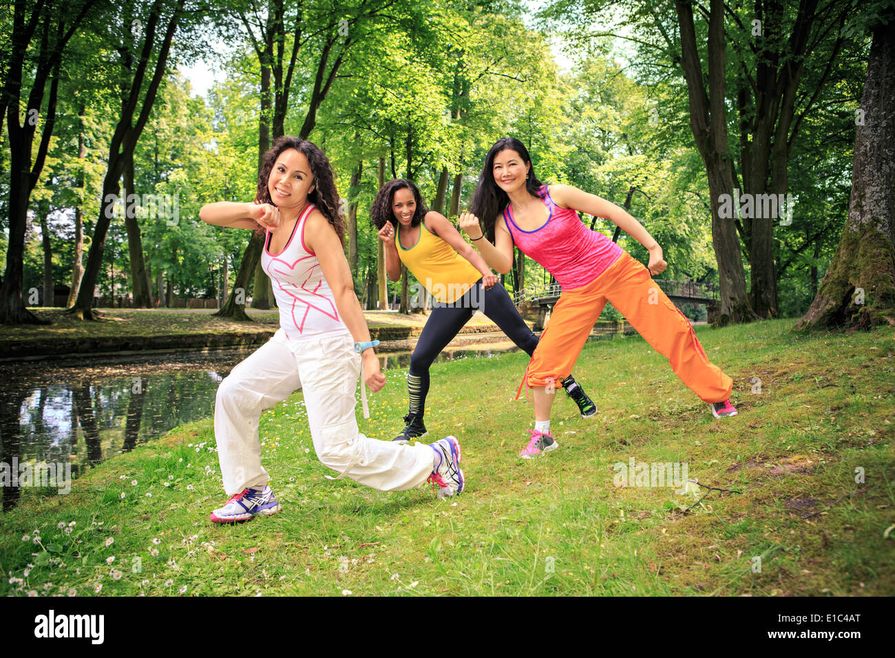 group of women dancing fitness dance zumba or aerobics in an old park Stock Photo
