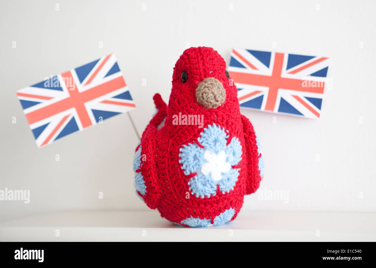 Union Jack carrying patriotic crocheted bird using African Flower Pentagons Stock Photo