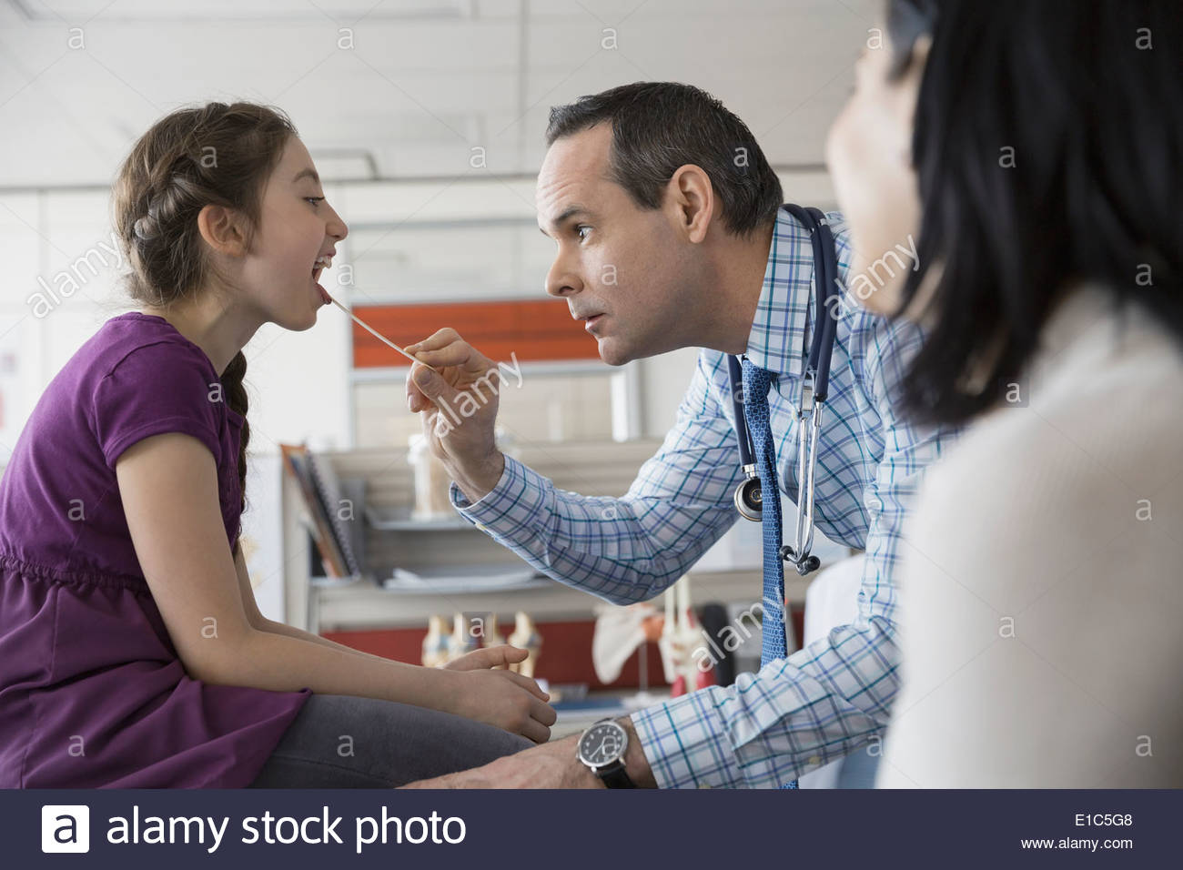 Pediatrician checking patientÕs mouth in office Stock Photo