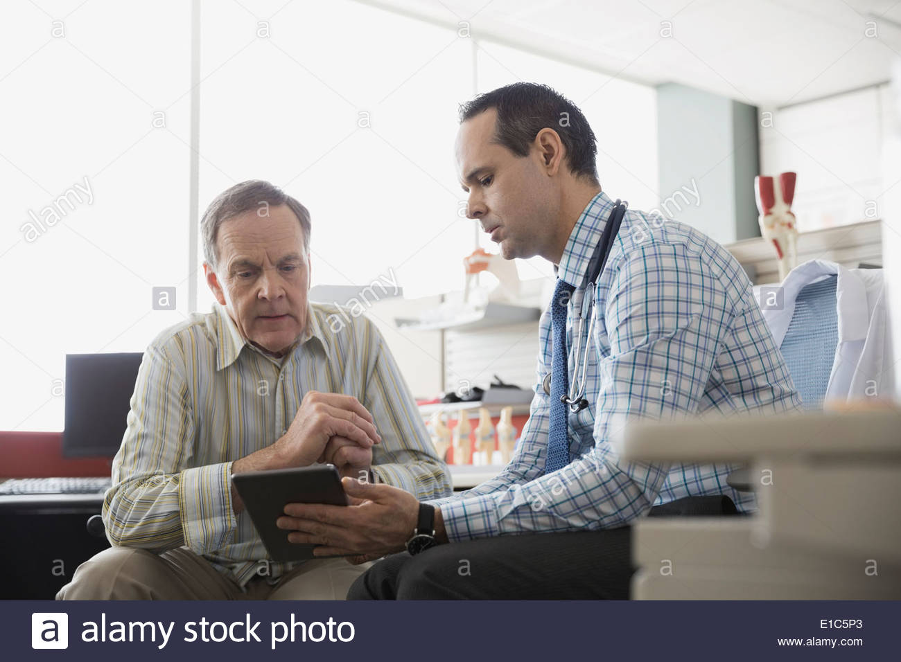 Doctor and senior patient using digital tablet Stock Photo