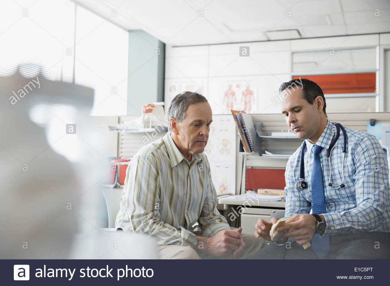 Doctor and patient looking at anatomical model Stock Photo