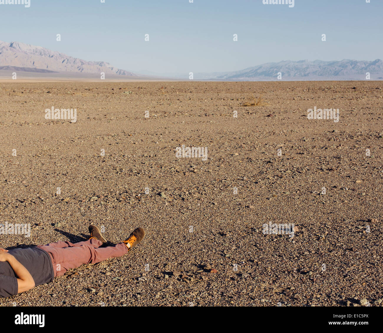 A man lying on his back on the ground in the desert Stock Photo - Alamy