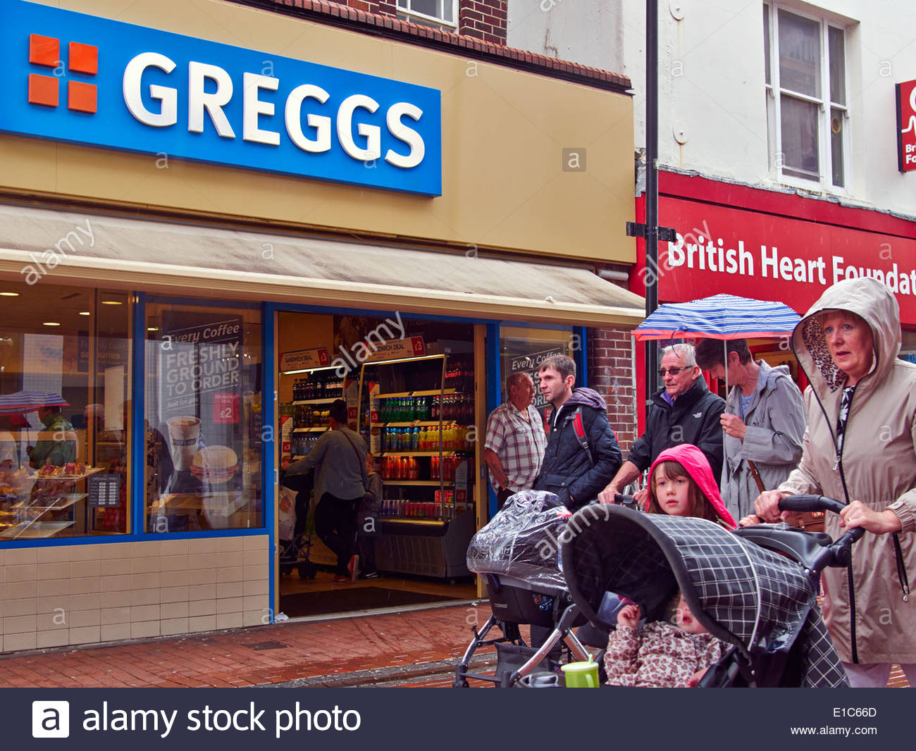 people shopping in the rain in neath town centre south wales Stock
