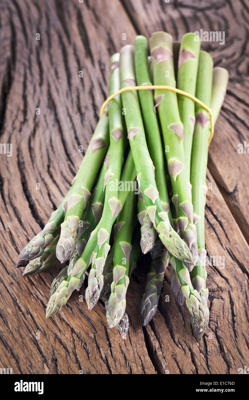 Bunch of asparagus on a wooden table. Stock Photo