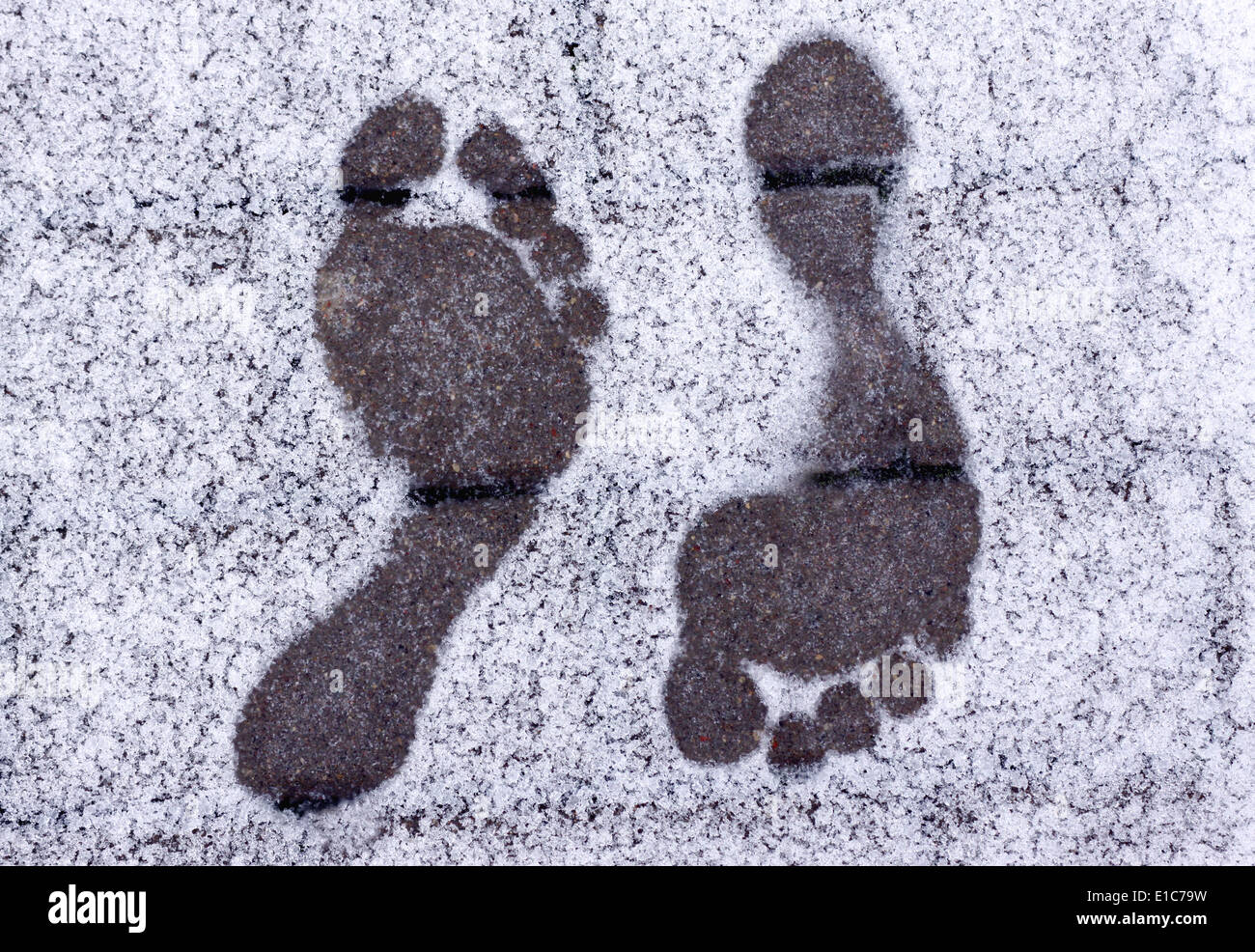 Two opposite barefoot footprints on snow at winter Stock Photo