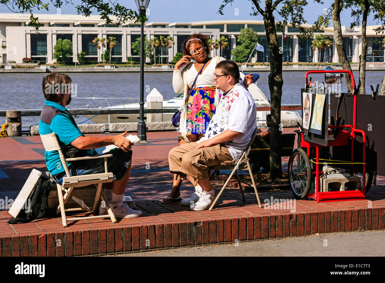 Street artist draws characature faces of passing people sited on the Savannah Riverfront Stock Photo