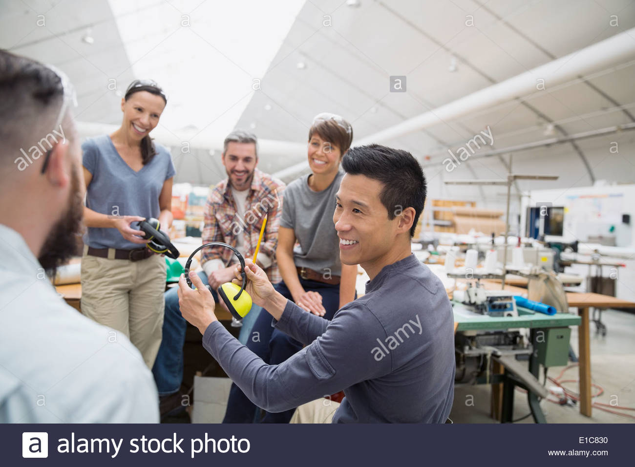 Workers with ear protectors in textile manufacturing plant Stock Photo